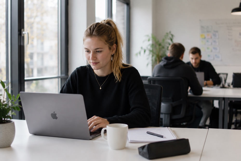 Studentin arbeitet am Laptop mit Notizen